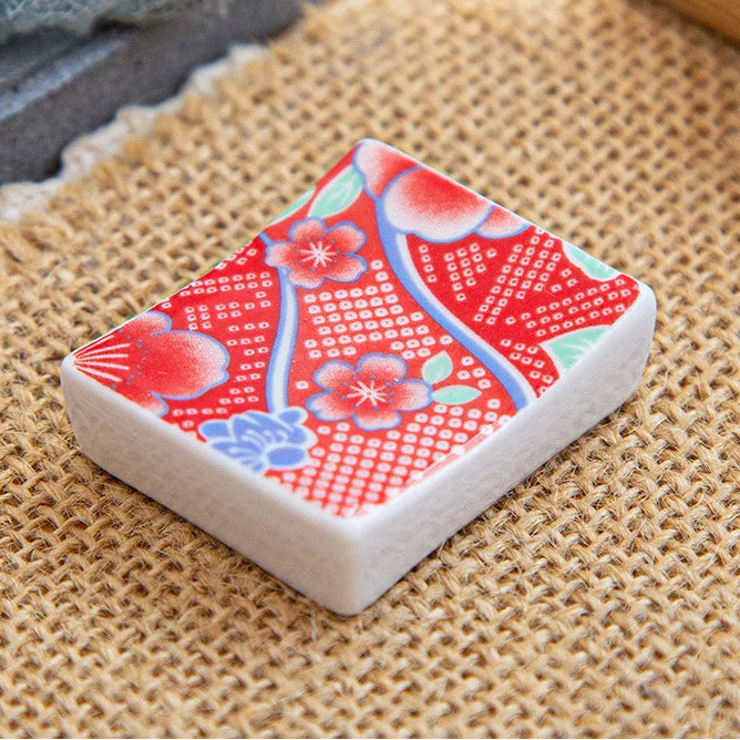 Small decorative kawaii chopstick holders with floral pattern on a textured surface