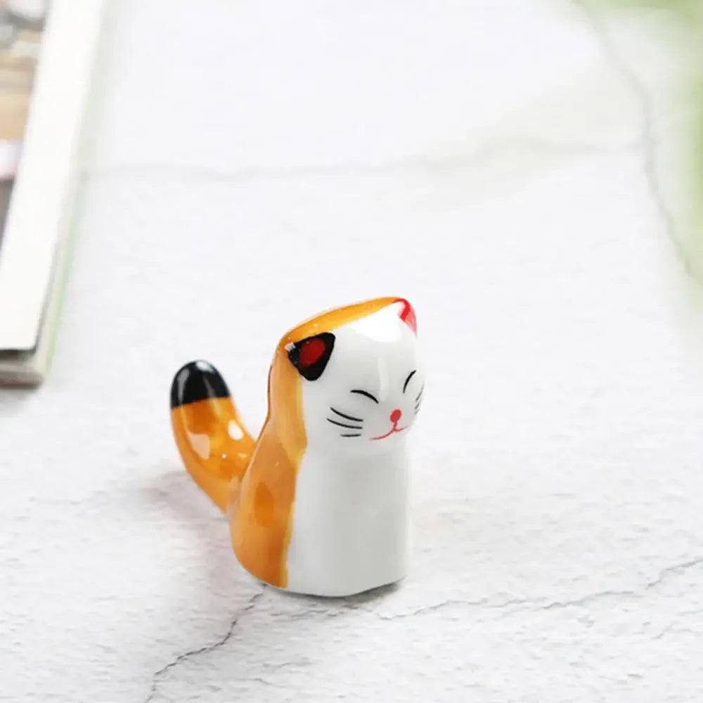 Ceramic kawaii cat-shaped object on a light gray surface
