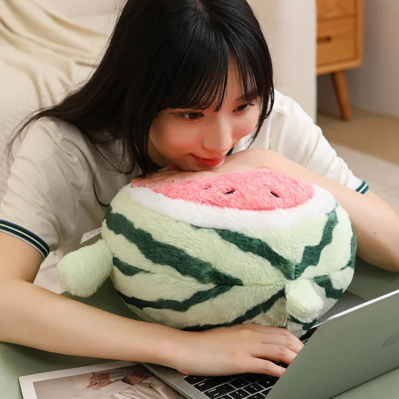Person using a laptop with a kawaii plush watermelon toy on their lap