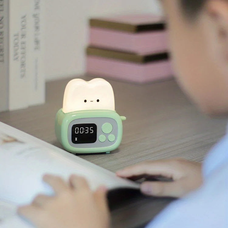 Children's kawaii night light with digital display on a table, child reading book in foreground