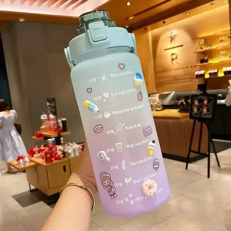 Light blue and purple kawaii water bottle with cartoon designs held in a hand, indoor setting.