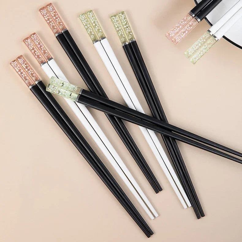 Set of black and white kawaii chopsticks with decorative ends on a beige background