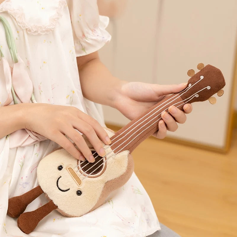Person holding a kawaii plush toy guitar with a smiley face on a wooden floor.