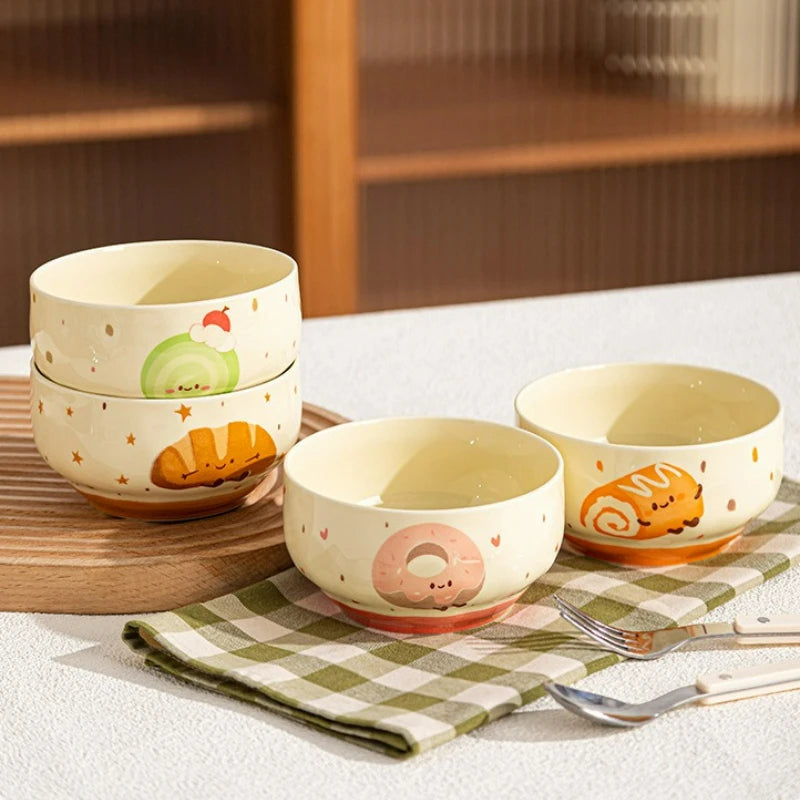 Four kawaii bowls on a table with food designs on them
