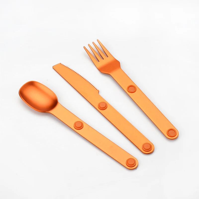 Orange plastic kawaii utensils set with spoon, knife, and fork on a white background