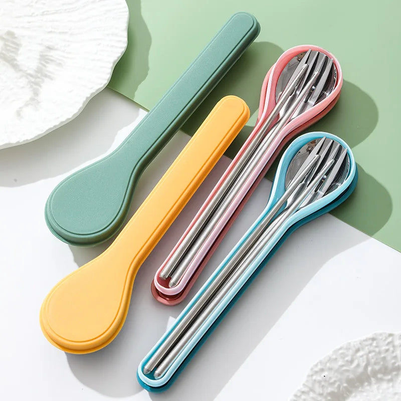 Set of colorful stainless steel kawaii utensils with case on a light background