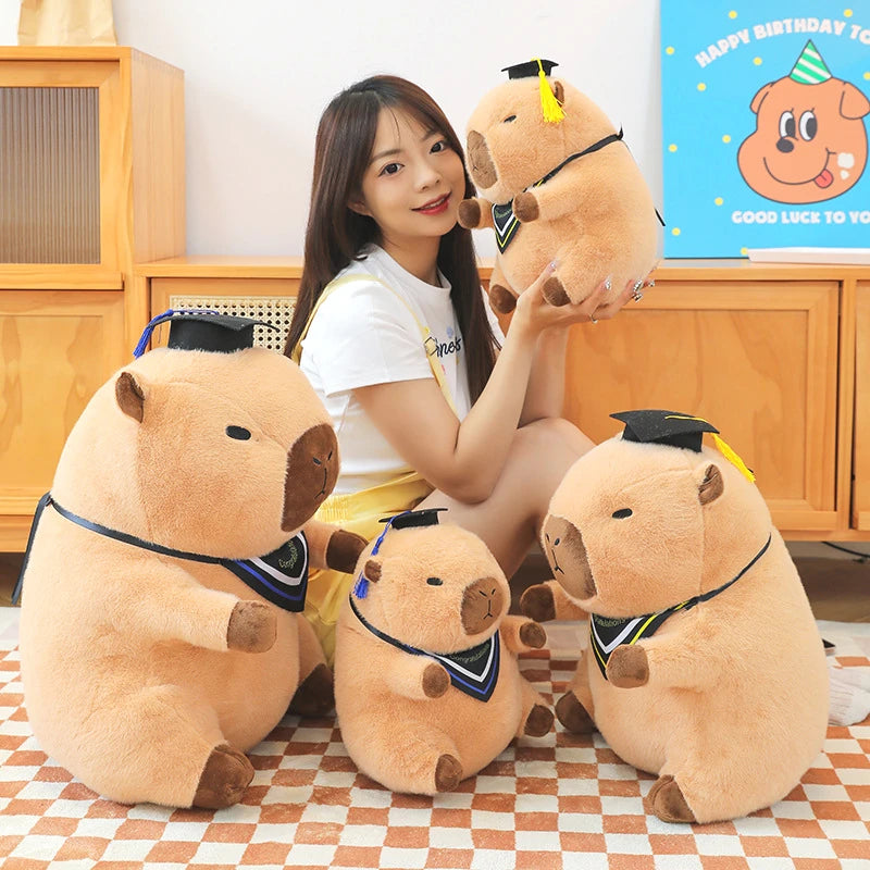 Woman holding a large kawaii plush bear with graduation attire on a checkered floor.