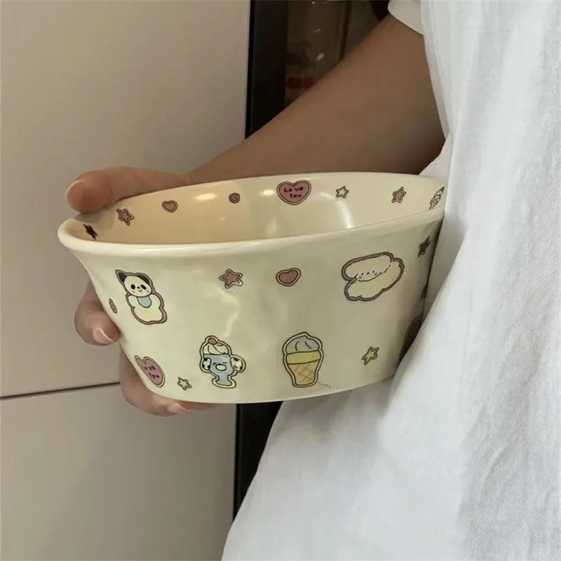 Person holding a decorative ceramic kawaii ramen bowl with cartoon illustrations.