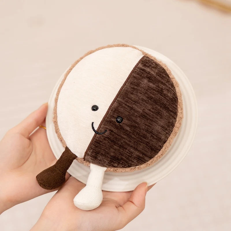 Kawaii plush toy resembling a half-circle with a face, held in a hand against a neutral background