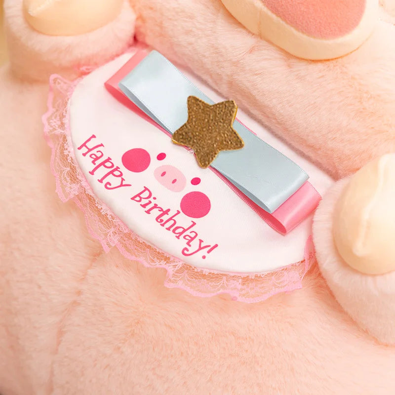 Small kawaii pig plush toywith 'Happy Birthday!' text on a soft pink background