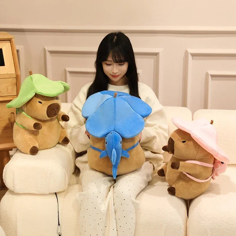 Woman sitting on a couch with three kawaii plush toys shaped like animals wearing hats.