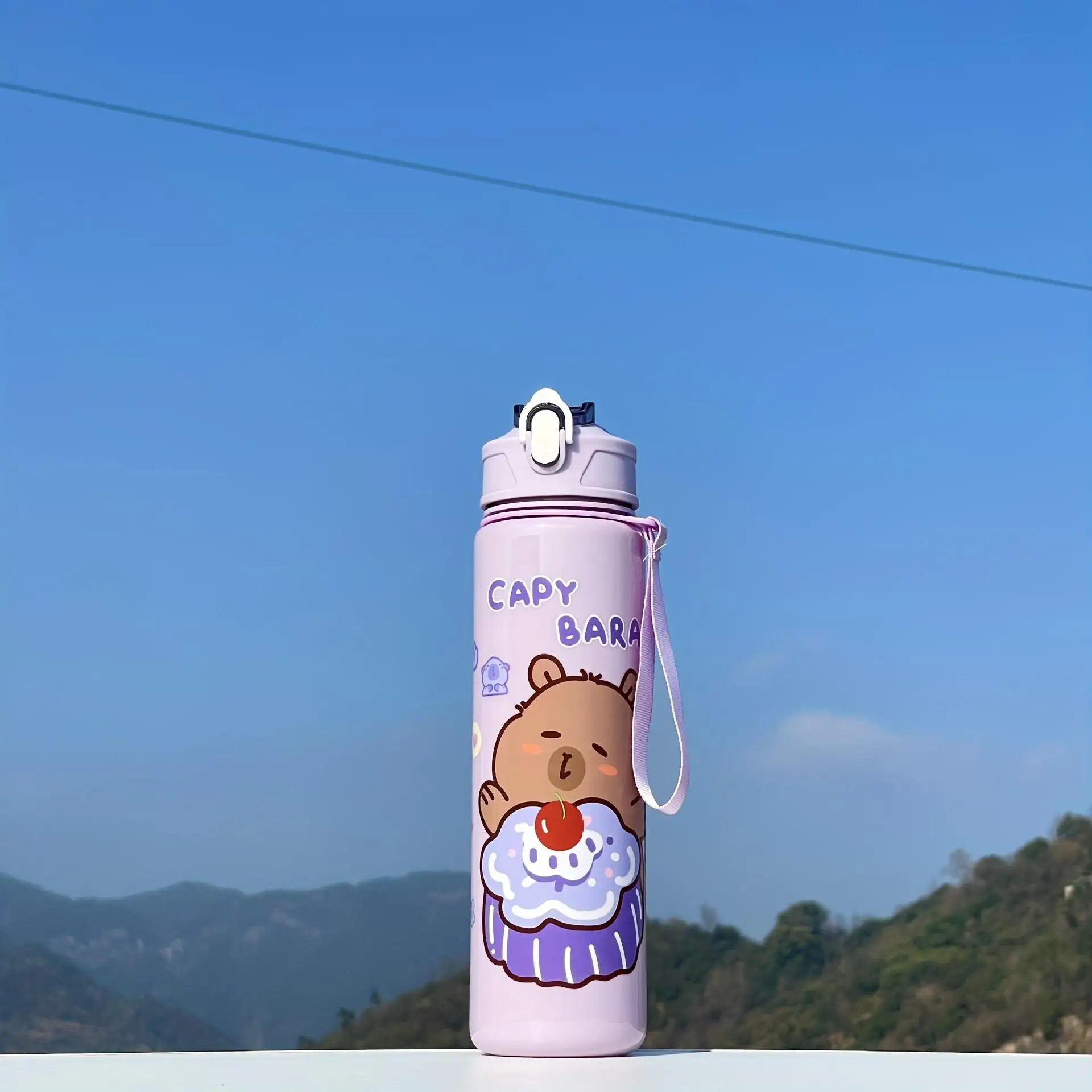 Capybara-themed kawaii water bottle with a scenic background