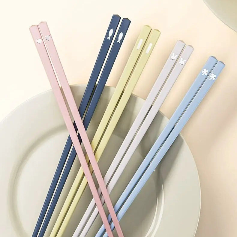 Set of colorful kawaii chopsticks on a white plate with text in Chinese.