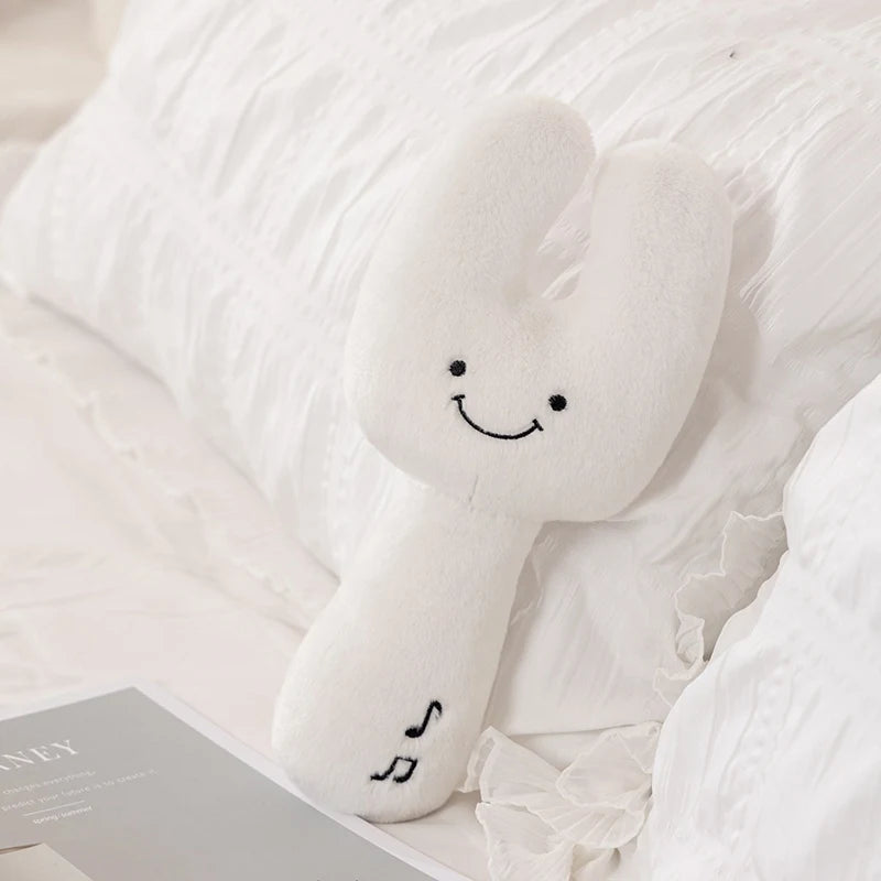 White kawaii plush toy with a smiley face on a white surface