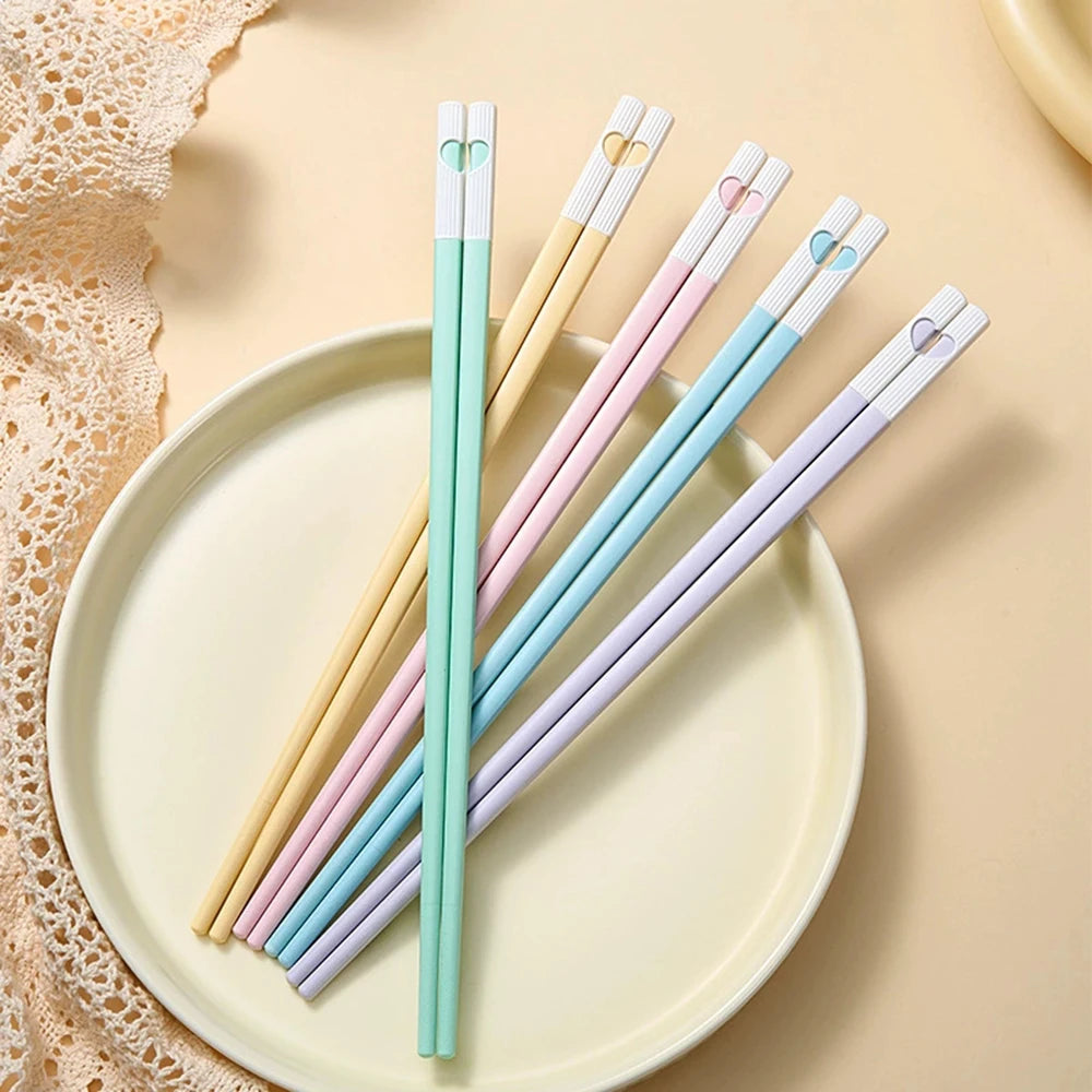 Set of colorful kawaii chopsticks on a beige plate with a textured background