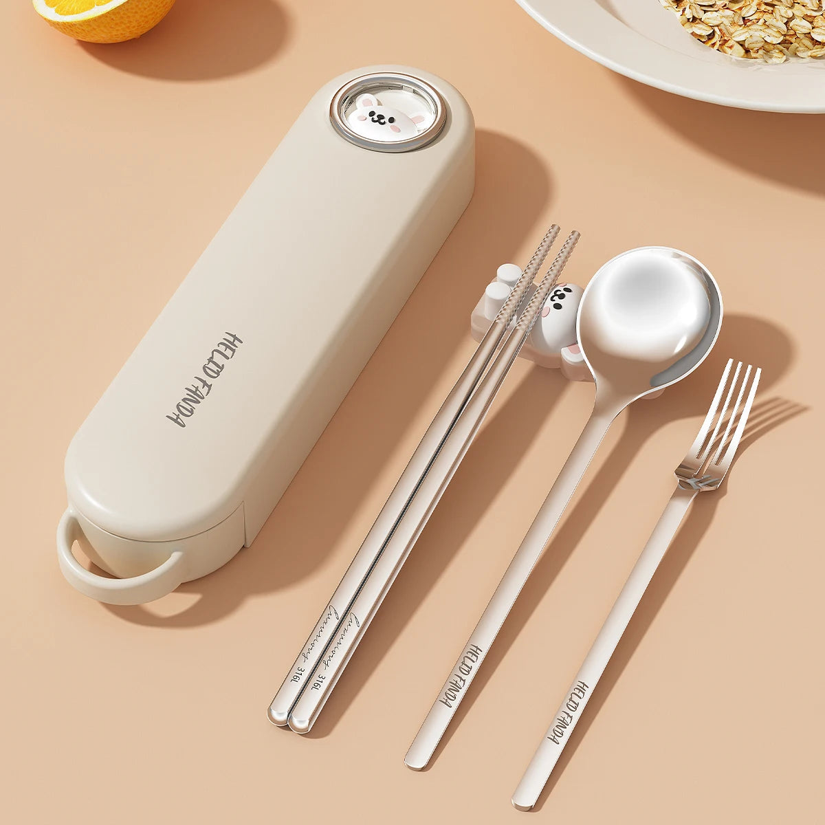Set of silver kawaii utensils with a beige case on a beige surface