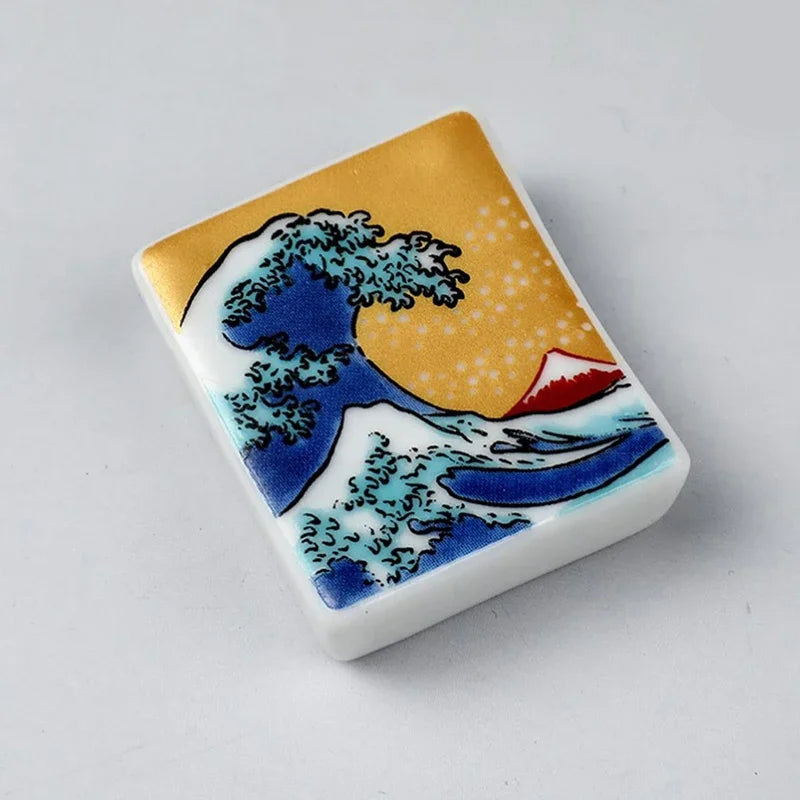 Decorative kawaii chopstick holders with wave design on a white background