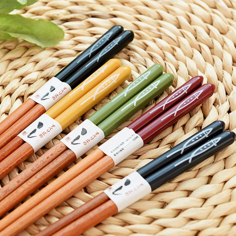 Set of colorful kawaii chopsticks with branded labels on a woven surface