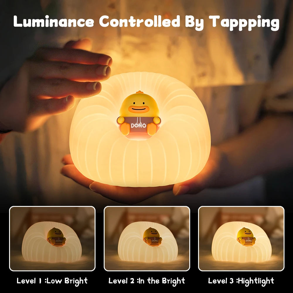 Hand holding a round night light with kawaii cartoon character, showing different luminance levels.