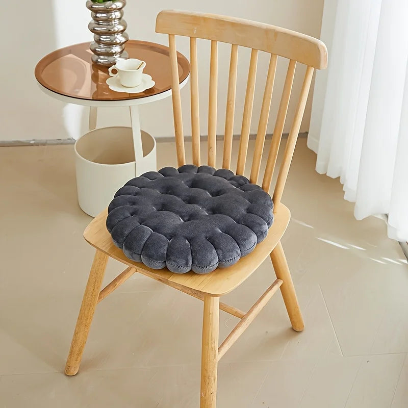 Gray kawaii cushion on a wooden chair with a small round table in the background