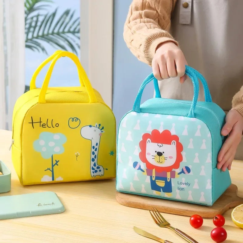 Two kawaii lunch bags, one yellow with a giraffe design and one blue with a lion design, on a table.