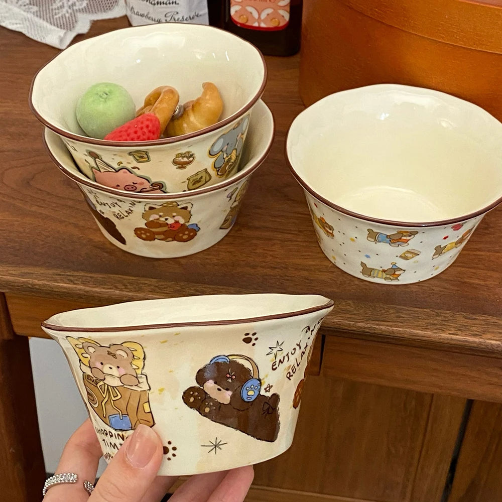 Set of ceramic kawaii ramen bowls with cartoon bear designs on a wooden surface.
