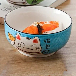 Kawaii bowl with a cartoon cat design containing sushi on a wooden surface