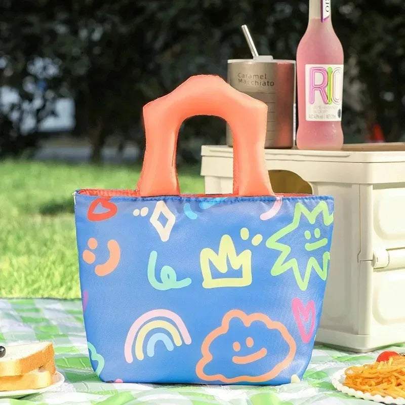 Colorful patterned kawaii bag with a handle on a picnic setup outdoors.