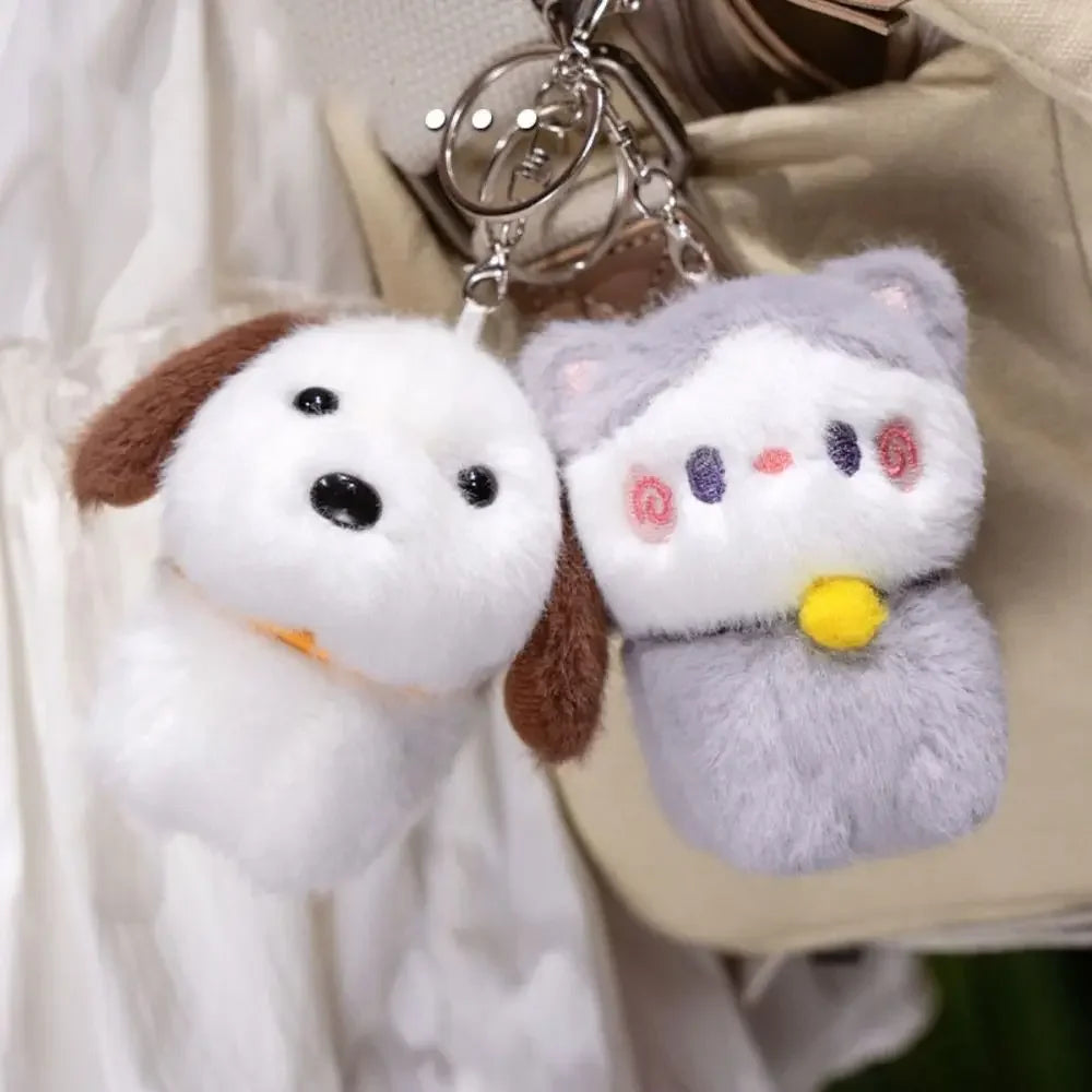 Kawaii plush dog and cat keychains hanging from a bag.