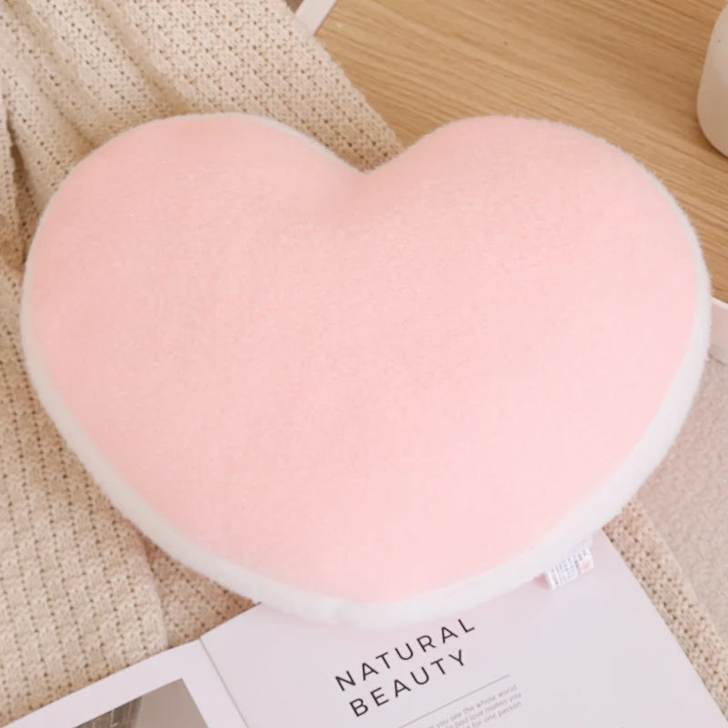 Heart-shaped pink kawaii cushion on a textured surface with 'Natural Beauty' magazine.