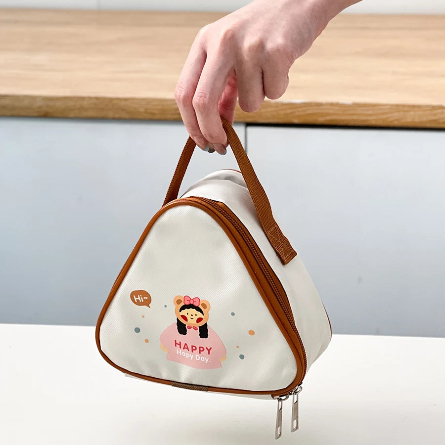 Triangle-shaped pouch with kawaii cartoon character and 'Happy New Day' text, held by a hand on a neutral background.