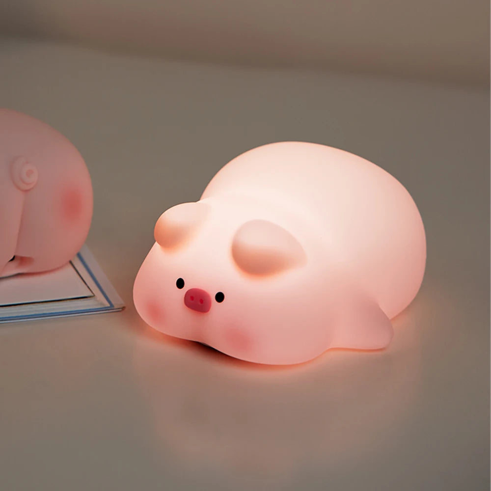 Pink pig-shaped kawaii night light on a gray surface