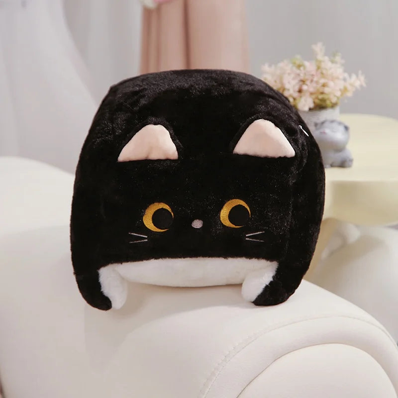 Black cat-shaped kawaii plush toy on a white surface with a blurred background