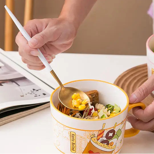 Kawaii ramen bowl with lid and spoon, featuring a 'Gourmet' design, on a table.