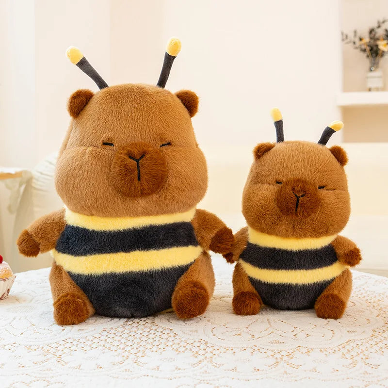 Two brown kawaii plush toys with bee costumes on a white surface.