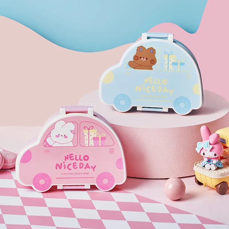Two cute car-shaped kawaii bento boxes with cartoon characters on a pink and white checkered background.