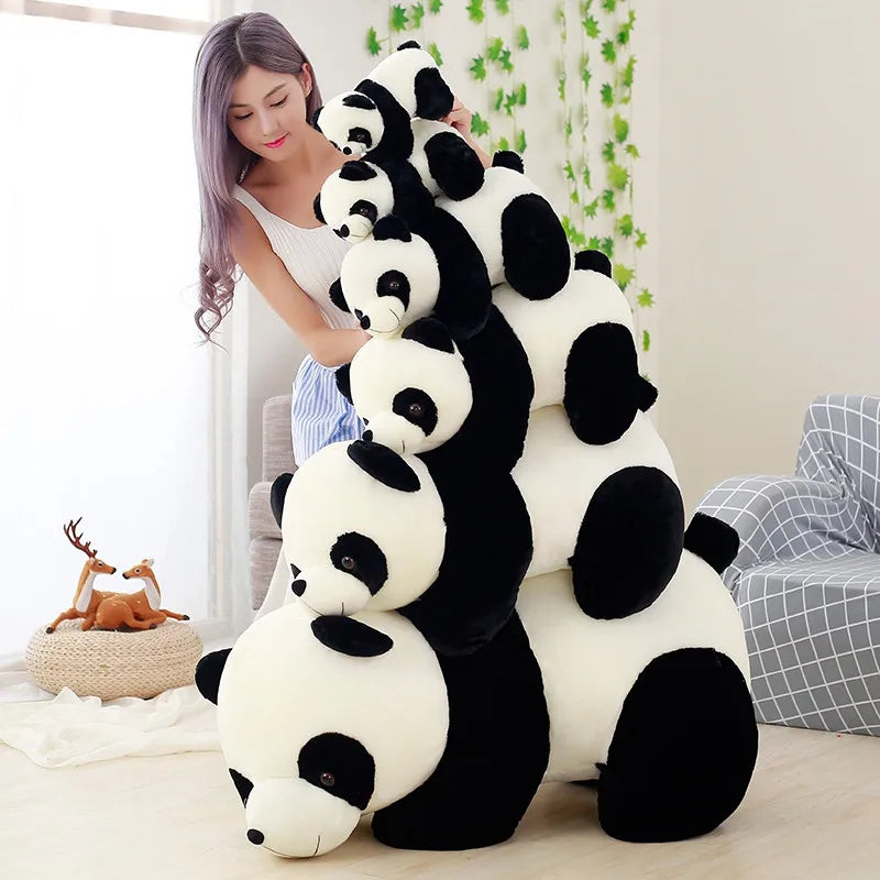 Woman holding a stack of large panda kawaii plush toys in a room with a deer figurine and plants.