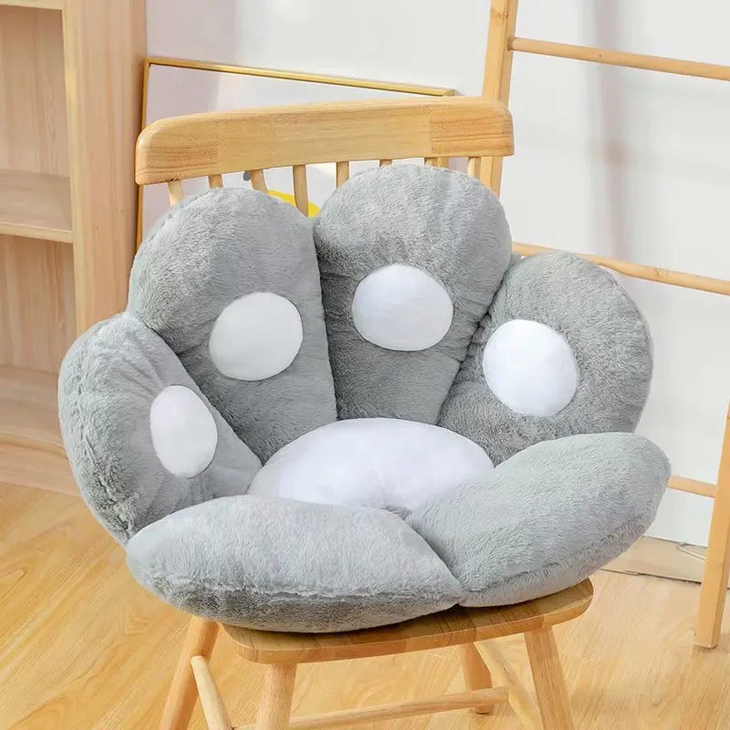 Flower-shaped gray kawaii cushion with white polka dots on a wooden chair.