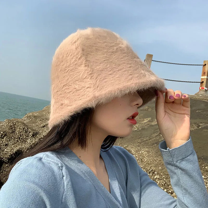 Person wearing a fluffy pink Kawaii hat by the sea