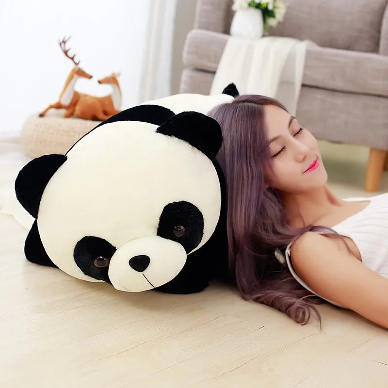 Person lying on a large panda-shaped kawaii pillow in a cozy living room.