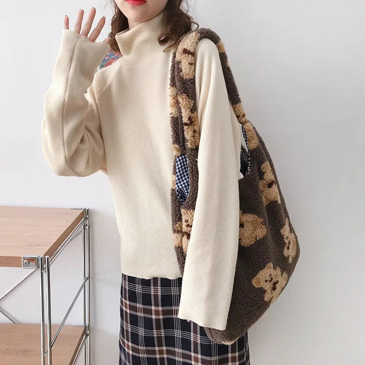 Person holding a brown drawstring bag with kawaii teddy bear patterns against a white background