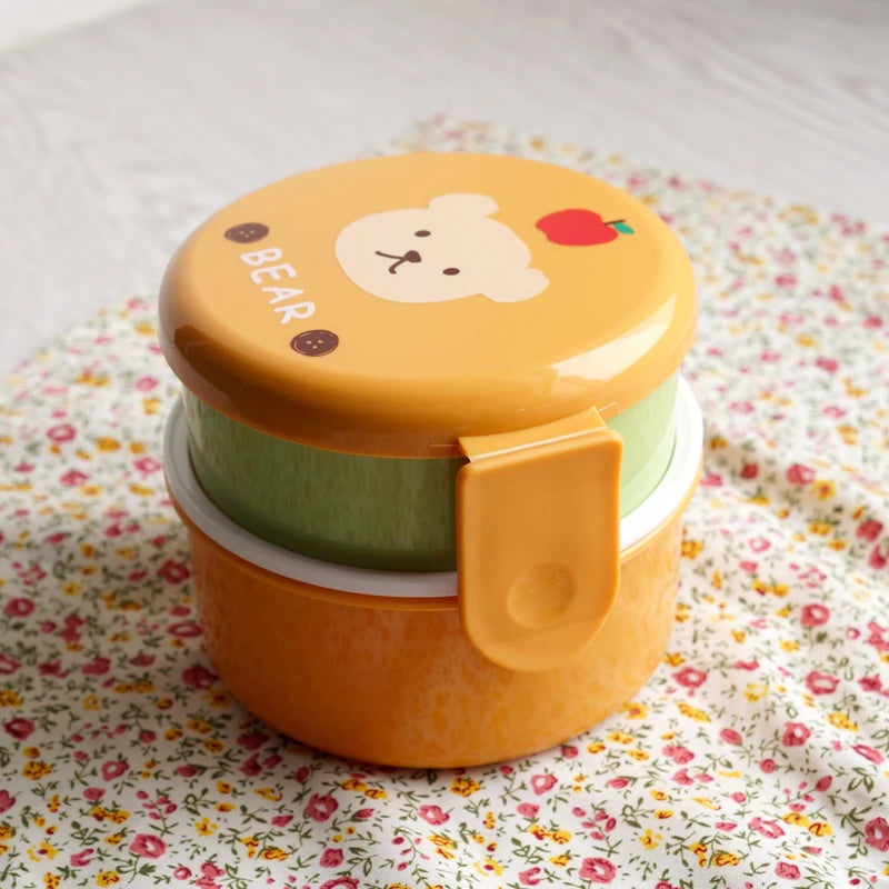 Yellow kawaii lunch box with bear design on a floral fabric background