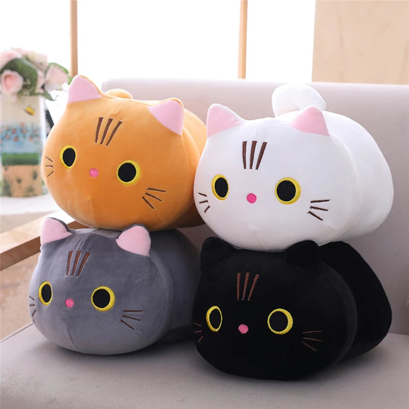 Four colorful cat-shaped kawaii cushions on a light surface with a blurred background