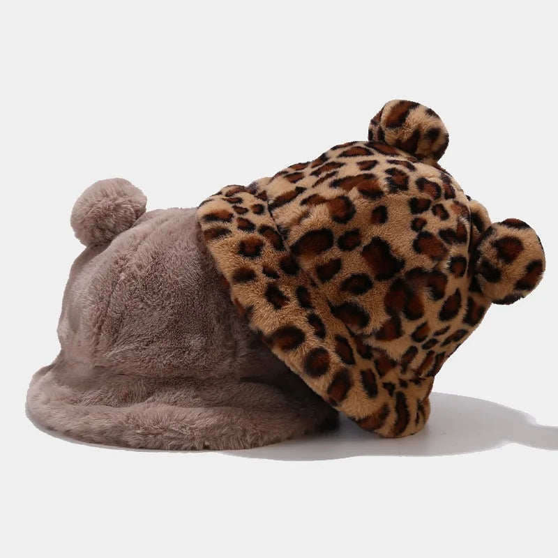 Two plush Kawaii hats, one with a leopard print pattern and the other plain gray, on a white background.