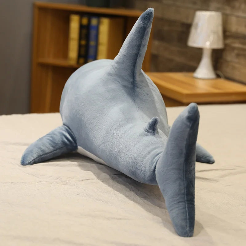 Kawaii plush shark toy on a bed with a blurred background