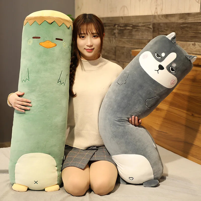 Woman holding two large kawaii plush toys, one green and one gray, against a wooden wall.