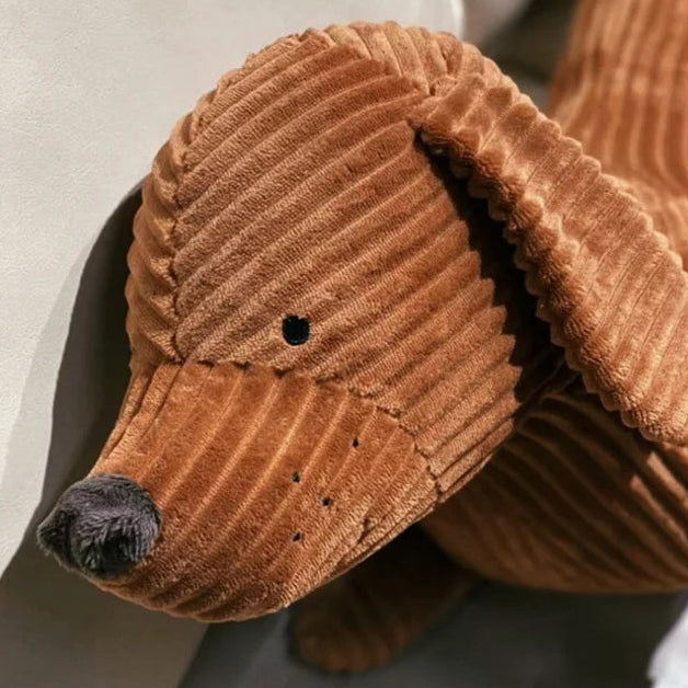 Brown corduroy dog kawaii toy with a black nose on a light background