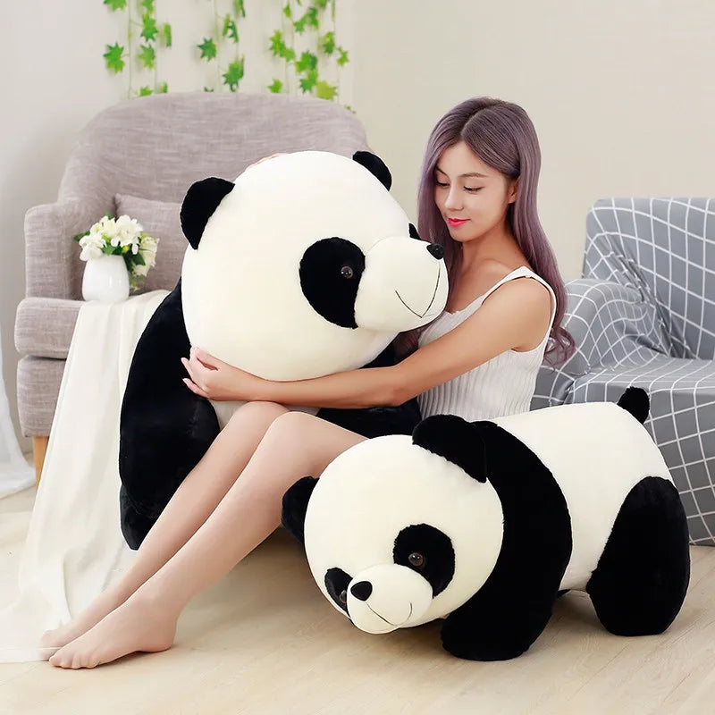 Woman holding a large kawaii plush panda toy in a cozy living room.