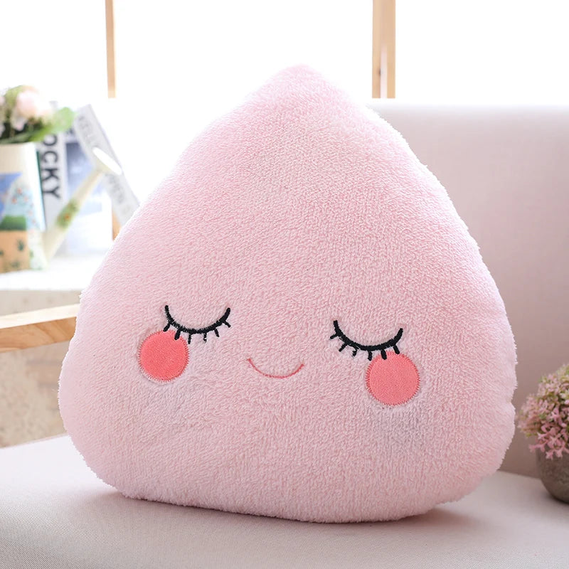 Pink kawaii plush toy shaped like a teardrop with a face on a light-colored surface.
