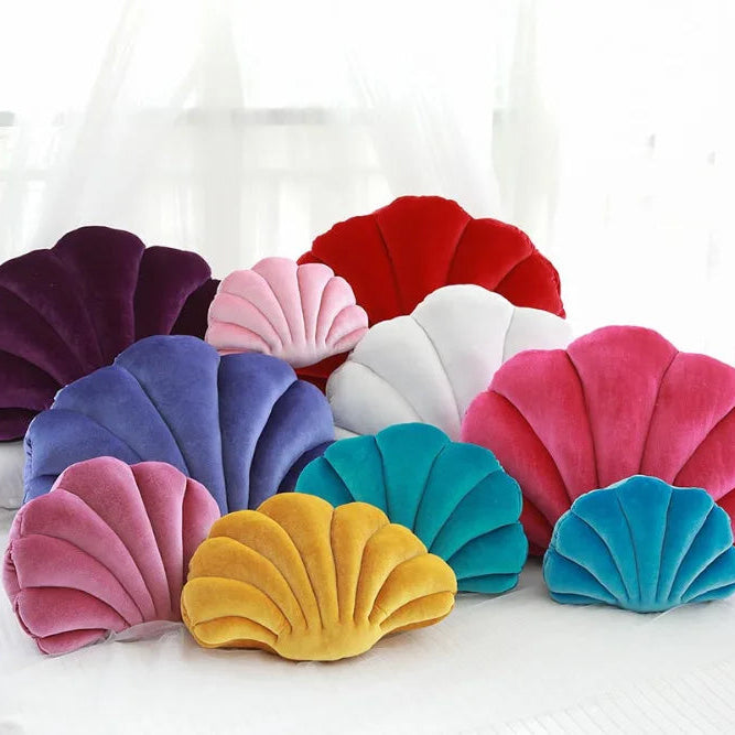 Colorful shell-shaped kawaii cushions on a white background